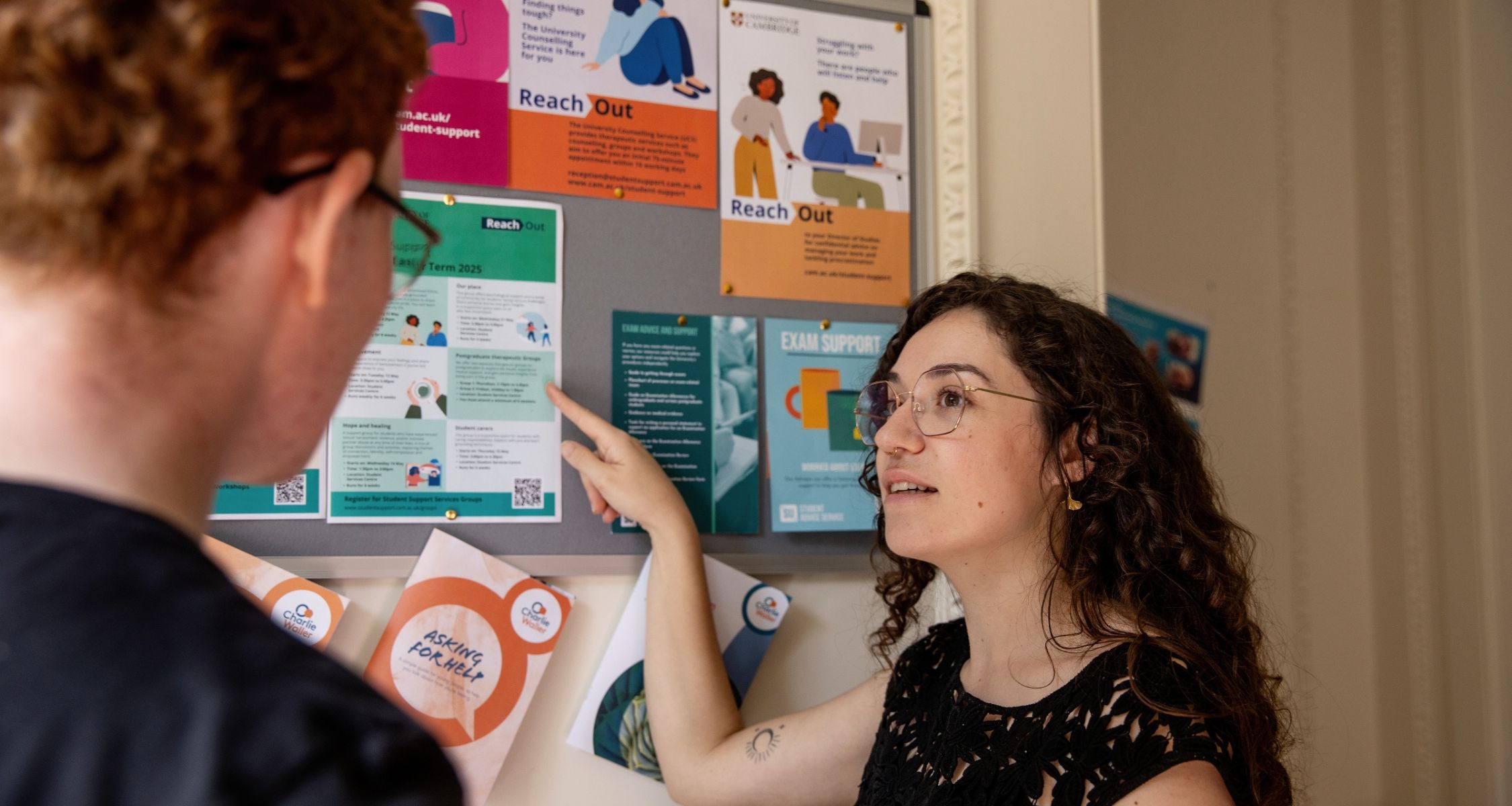 Student and staff member reading an information board