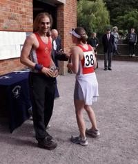 A sportsman and a sportswoman standing opposite each other at a sporting event.