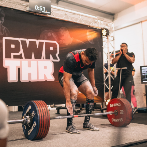 A young man at a weight lifting competition getting ready to lift.