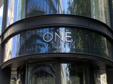 A glass facade of an office building with number one spelt out over the entrance