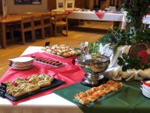 A table decorated with a Christmas tree and having a selection of snacks. 