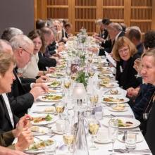 Diners sitting at a long table having dinner